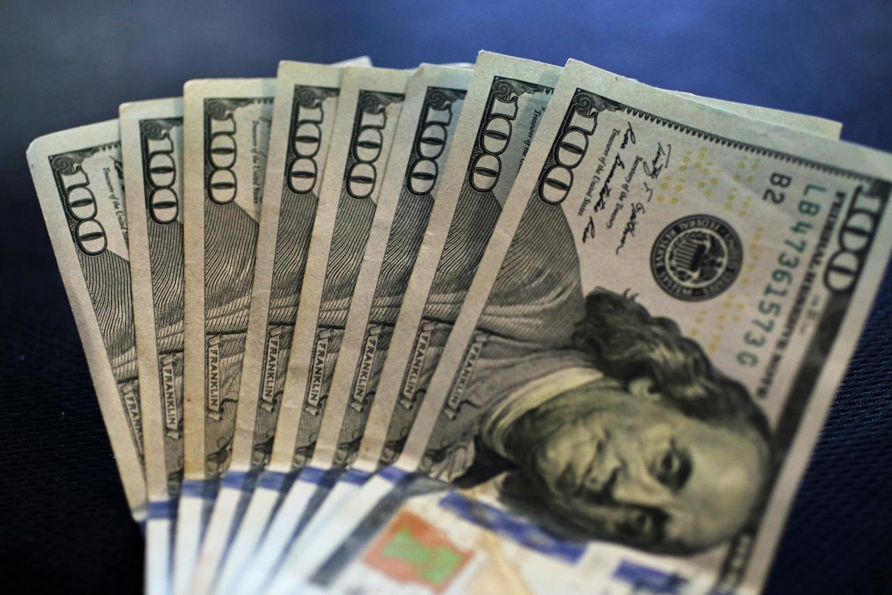 a stack of twenty dollar bills sitting on top of a table