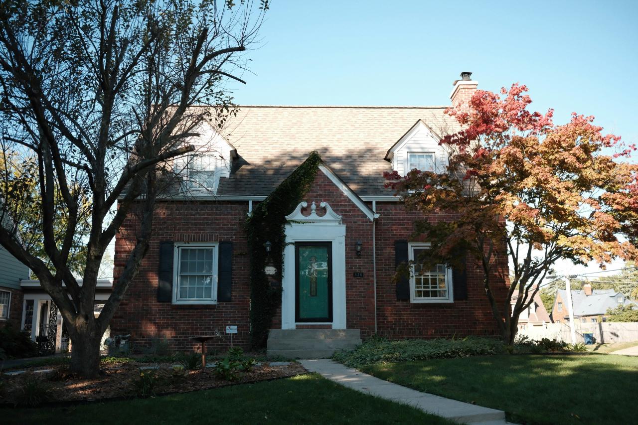 A brick house with a walkway and trees.